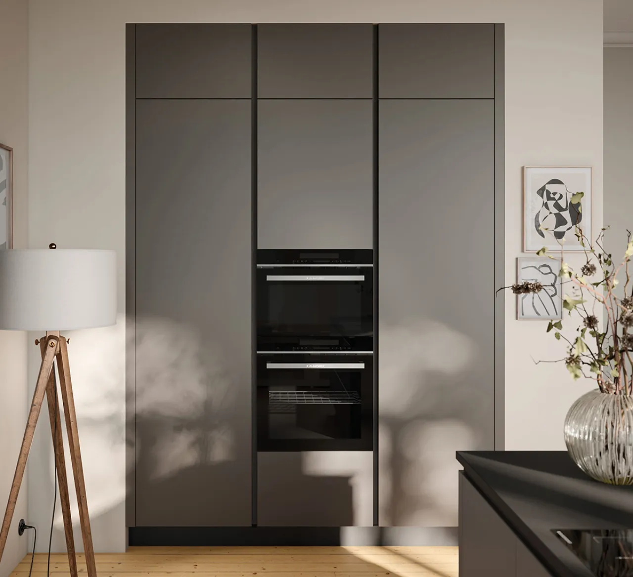 Zeitlose graue Küche mit integrierten Backöfen und minimalistischer Linienführung. Hochwertige Materialien, warme Lichtstimmung und moderne Wohnatmosphäre.